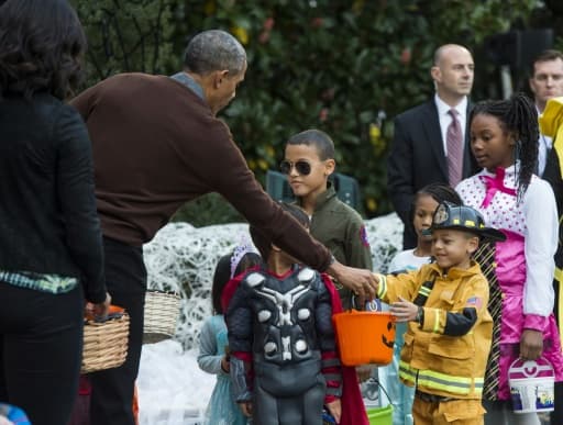 Le président Barack Obama et son épouse Michelle distribuent des bonbons aux enfants lors de la réception annuelle d'Halloween à la Maison Blanche, le 30 octobre 2015 à Washington