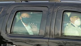 Le président américain Donald Trump salue ses symathisants depuis la limousine présidentielle lors d'une brève sortie de l'hôpital militaire de Walter Reed à Bethesda, près de Washington, le 4 octobre 2020
