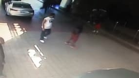 Un extrait de la vidéo montrant les rappeurs jouer aux gros bras sur un parking.