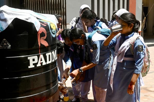 Des élèves remplissent leurs bouteilles pour s'hydrater lors d'une chaude journée d'été, dans une école de Dhaka, le 28 avril 2024, en raison de la vague de chaleur actuelle. 