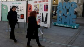 Des visiteurs regardent des affiches dans le cadre d'une exposition lors du 52e Festival international de la bande dessinée d'Angoulême, le 30 janvier 2025