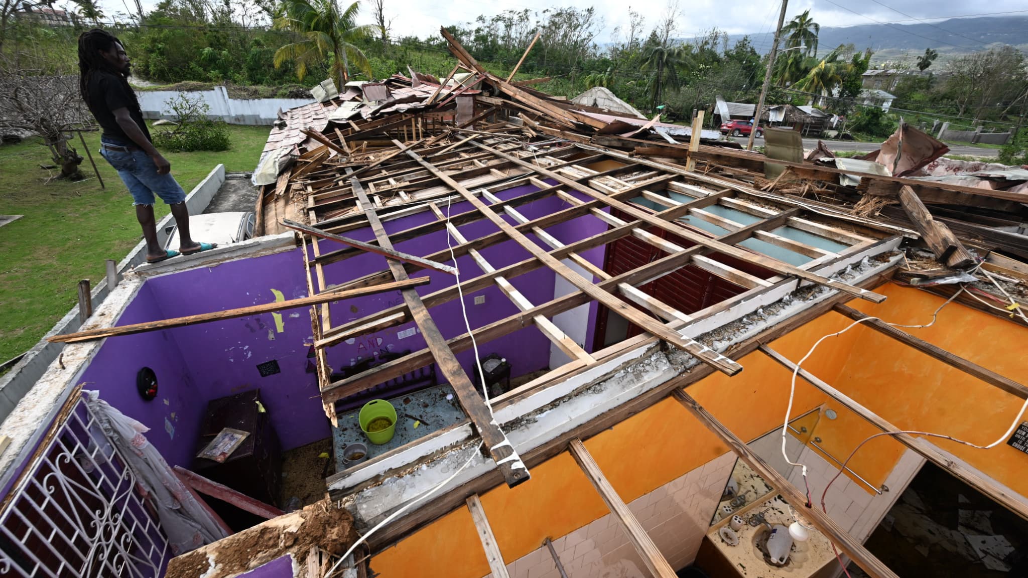 Un homme constate les dégâts provoqués par l'ouragan Melissa depuis le toit de la maison d'un voisin à Iongwood, St Elizabeth, en Jamaïque le 29 Octobre 2025 Un homme constate les dégâts provoqués par l'ouragan Melissa depuis le toit de la maison d'un voisin à Iongwood, St Elizabeth, en Jamaïque le 29 Octobre 2025