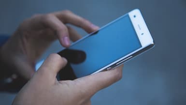 Une personne tenant un téléphone. (photo d'illustration)
