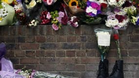 Hommage à Lee Rigby, à Londres, près de l'endroit où il a été assassiné mercredi. La police antiterroriste britannnique a arrêté samedi trois hommes en lien avec l'assassinat du militaire. /Photo prise le 24 mai 2013/REUTERS/Luke MacGregor