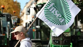 Un agriculteur brandit le drapeau de la Fédération nationale des syndicats d'exploitants agricoles (FNSEA), à Strasbourg le 21 octobre 2024.