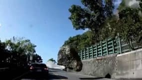 Un roche chute sur une route et s'apprête à percuter une voiture, à Taïpei, à Taïwan, le 3 avril 2023, dans le contexte du fort séisme qui a frappé l'île.