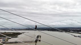 Un militant écologiste du groupe Just Stop Oil grimpe sur un pont près de Londres, provoquant des embouteillages, le 17 octobre 2022