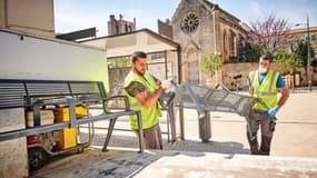 Des agents de voirie retirant les bancs publics de la ville de Béziers.