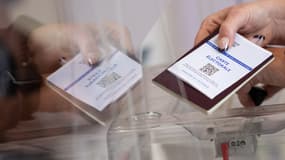 Une électrice présente sa carte électorale et son passeport, dimanche 24 avril 2022, à l'occasion du second tour de l'élection présidentielle à Bouée, en Loire-Atlantique