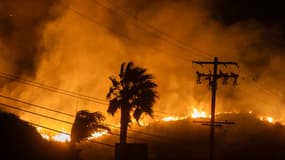 L'incendie Franklin brûle à côté de lignes électriques sur la Pacific Coast Highway dans la matinée du 11 décembre 2024 près de Malibu, en Californie.