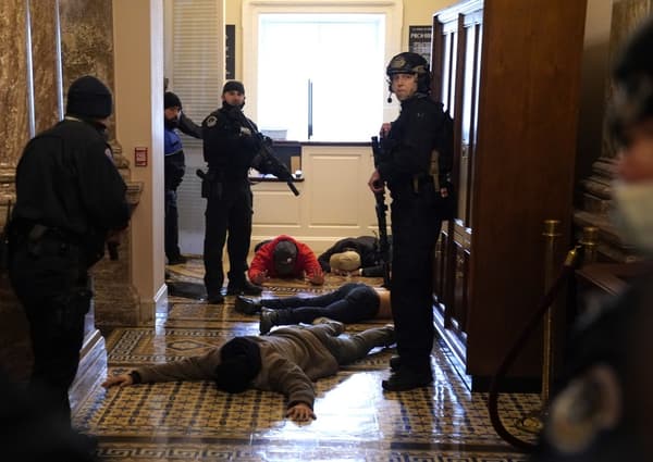 Des manifestants arrêtés et allongés au sol à l'extérieur de la chambre des représentants.