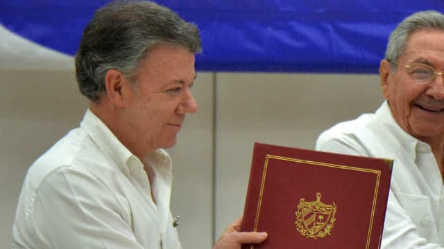 Le 23 juin 2016, à La Havane, poignée de main historique entre le chef des Farc, Timoleon Jimenez (à gauche), et le président de la Colombie, Juan Manuel Santos, sous les yeux du chef d'Etat cubain Raul Castro. 