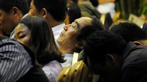 Yan Jiacheng, au centre, avec d'autres proches des disparus du vol MH370, dans un hôtel à Pékin le 23 avril.