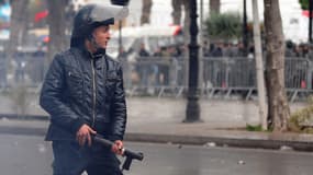 Un policier tunisien surveille le cortège de manifestants qui s'approche du ministère de l'Intérieur, à Tunis, jeudi 7 février.