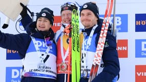 Les Français Eric Perrot et Emilien Jacquelin entourent Johannes Thingnes Boe sur un podium, décembre 2024