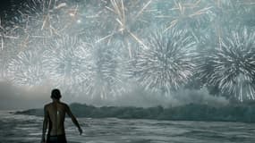 Un homme célèbre en regardant les traditionnels feux d'artifice du Nouvel An depuis la plage de Copacabana à Rio de Janeiro, au Brésil, le 1er janvier 2026.