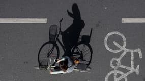 Une femme utilise son téléphone portable tout en faisant du vélo (illustration)