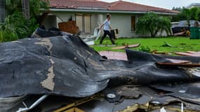 Une femme déblaie son jardin après le passage de l'ouragan Milton, en Floride, le 10 octobre 2024
