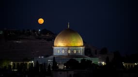 Une super lune bleue se lève derrière la mosquée du Dôme du Rocher dans le complexe de la mosquée al-Aqsa à Jérusalem, le 19 août 2024.