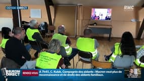 Des "gilets jaunes" réunis dans une salle de la mairie de Brionne, regardent les annonces d'Emmanuel Macron