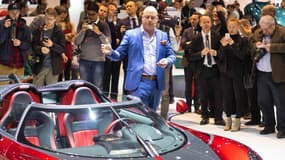 Christian von Koenigsegg, en costume bleu, en pleine présentation d'un nouveau modèle sur son stand, au salon automobile de Genève le 7 mars.