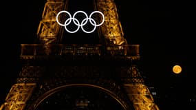 La pleine lune apparaît derrière la Tour Eiffel habillée des anneaux des Jeux olympiques, lors de la pleine lune des fraises, le 22 juin 2024