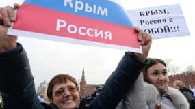 Deux femmes brandissent des banderoles sur lesquelles est écrit: "Crimée, Russie" (à gauche) et "Crimée, Russie avec vous" (droite) pendant une manifestation à Moscou, le 7 mars 2014.
