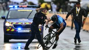 Un CRS intercepte un cycliste amateur tentant de franchir la ligne d'arrivée du Tour de France à Valence le 23 juillet 2024
