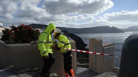 Des employés municipaux coupent l'accès à une ruelle du village d'Oia, à Santorin, le 5 février 2025, après une série de secousses enregistrées sur l'île grecque. 