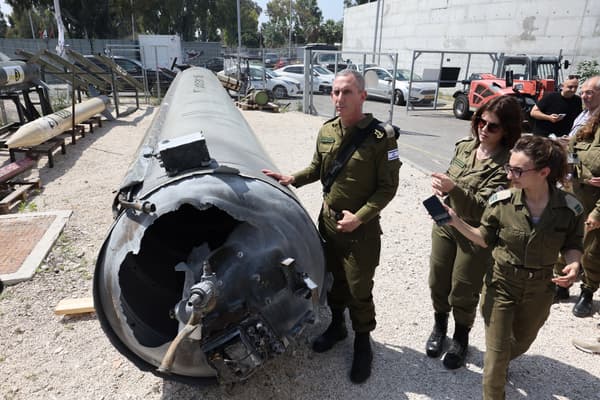 Le porte-parole de l'armée israélienne, le contre-amiral Daniel Hagari et d'autres membres de l'armée israélienne se tiennent à côté d'un missile balistique iranien tombé à la base militaire de Julis, près de la ville de Kiryat Malachi, dans le sud d'Israël, le 16 avril 2024. 