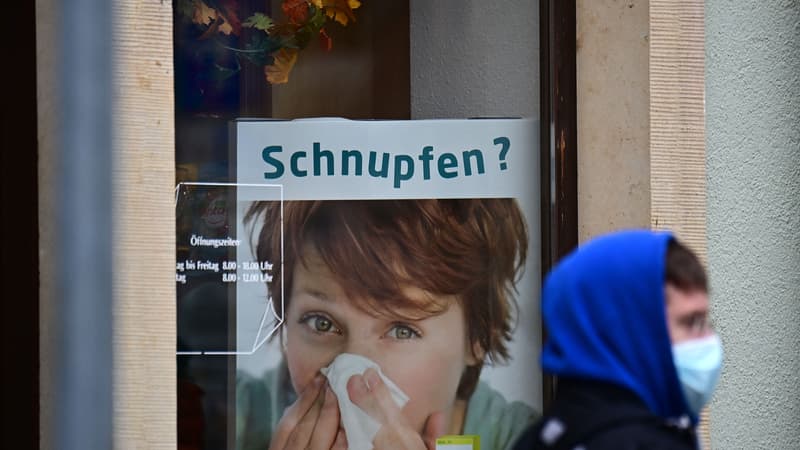 Un homme portant un masque pour se protéger contre le Covid-19 passe devant une pharmacie, en Allemagne, en novembre 2021.