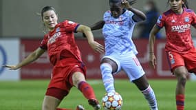 La milieu de terrain française du Bayern Munich, Viviane Asseyi, déborde son homologue espagnole de Lyon, Damaris Egurrola (g) et la défenseure française Perle Morroni, lors de leur match de poules de la Ligue des Champions, le 17 novembre 2021 à Munich