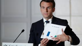 Le président français Emmanuel Macron montre un graphique lors d'une conférence de presse à l'issue du premier jour du sommet européen en visioconférence, à Pairs, le 25 mars 2021