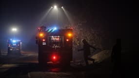 Un pompier marche alors qu'un feu de forêt se propage dans la zone proche de la plage du lac de Cazaux, près de La Teste-de-Buch, dans le sud-ouest de la France, le 15 juillet 2022.