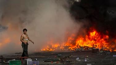 Barricade en flammes dans une rue de Bangkok, dimanche. Le gouvernement thaïlandais va instaurer un couvre-feu dimanche soir dans la capitale où les affrontements qui font rage depuis trois jours entre les manifestants et l'armée ont fait 24 morts. /Photo