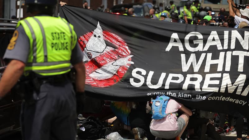 Des manifestants anti-racistes abrités derrière une barrière pour soigner leurs blessés, le 12 août 2017 à Charlottesville aux Etats-Unis. 