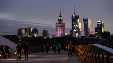 Des passants marchent au coucher du soleil sur le pont piétonnier qui traverse la Vistule et relie les deux rives de la ville de Varsovie, en Pologne, le 23 septembre 2025 (photo d'illustration).