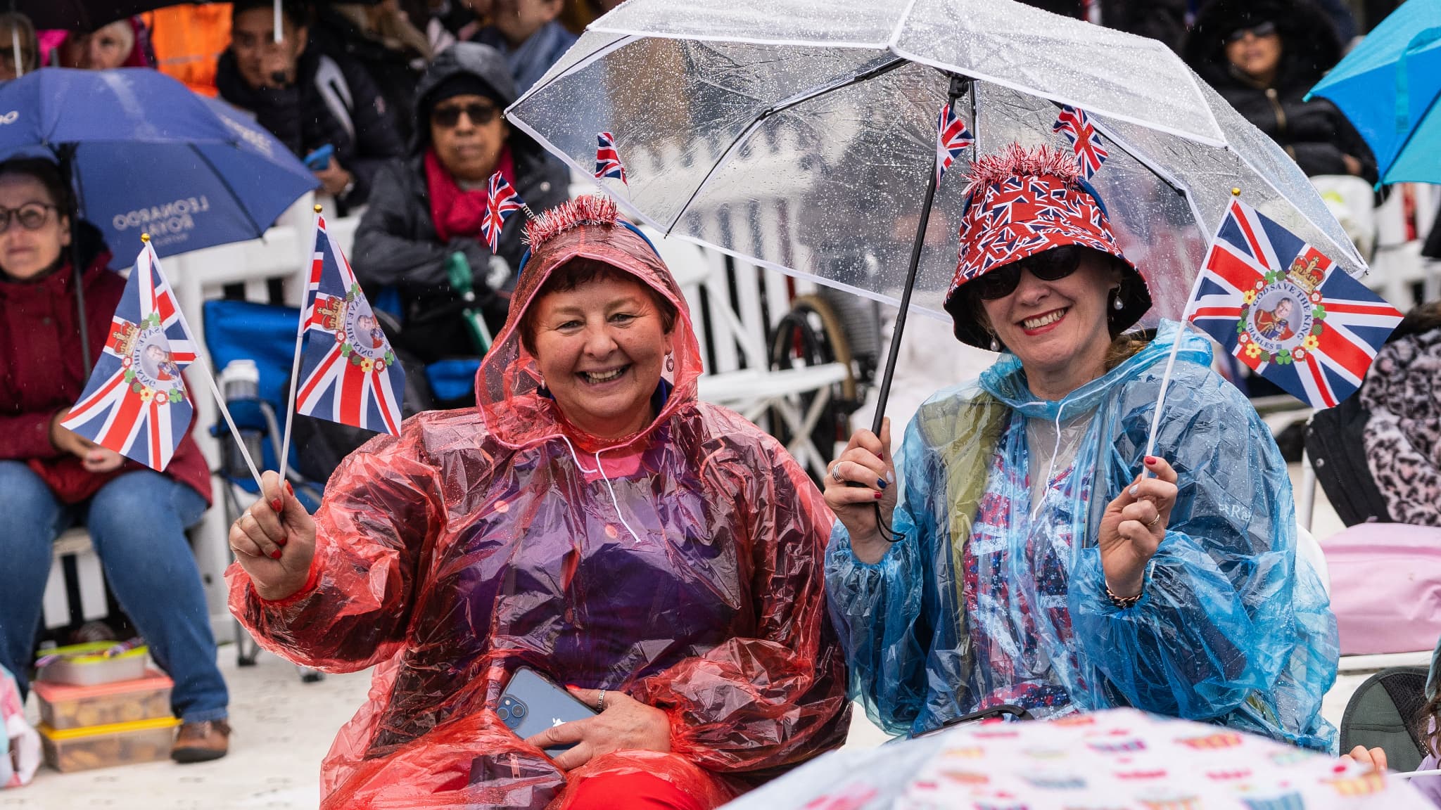 Les spectateurs patientent sous la pluie.