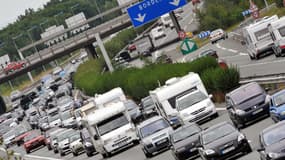 Des véhicules sont pris dans les embouteillages au niveau du péage de Virsac sur l'A10, le 16 août 2008. Le processus d'automatisation des péages autoroutiers pourrait déboucher dans l'avenir sur le "Free Flow" ou "système de péage en flux libres", un portique doté d'un dispositif vidéo et d'un laser qui permet à l'automobiliste de payer sans même ralentir. La première intégration opérationnelle d'un système complet de ce type en Europe aura lieu dès septembre en Irlande, sur le périphérique de Dublin, le M50. AFP PHOTO PIERRE ANDRIEU
PIERRE ANDRIEU / AFP