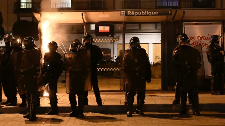La police anti-émeute protège un abribus "République" qui a été incendié lors d'une manifestation pour protester contre la réforme des retraites du gouvernement, le 22 mars 2023 à Rennes