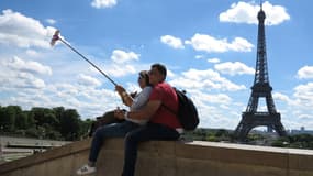 Un couple de touristes en train de se prendre en selfie devant la Tour Eiffel à Paris le 21 mai 2017 (Photo d'illustration).