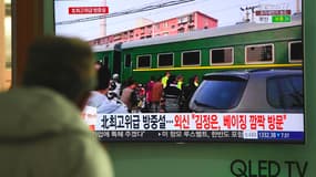 Un homme regarde à la télévision un reportage sur le train nord-coréen. 