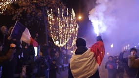 Des supporters célèbrent sur les Champs-Élysées la victoire de l'Équipe de France face au Maroc en demi-finale de Coupe du monde, le 14 décembre 2022.