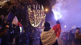 Des supporters célèbrent sur les Champs-Élysées la victoire de l'Équipe de France face au Maroc en demi-finale de Coupe du monde, le 14 décembre 2022