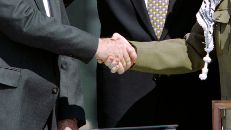 Yitzhak Rabin et Yasser Arafat, aux côtés de Bill Clinton, se serrent la main pour marquer leur rapprochement au moment des accords d'Oslo en septembre 1993.