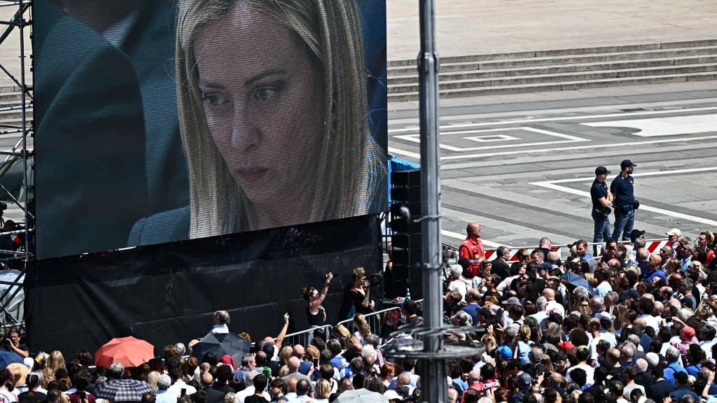 La Première ministre italienne, Giorgia Meloni, lors des obsèques de Silvio Berlusconi retransmises sur un écran géant devant la cathédrale de Milan, le 14 juin 2023 La Première ministre italienne, Giorgia Meloni, lors des obsèques de Silvio Berlusconi retransmises sur un écran géant devant la cathédrale de Milan, le 14 juin 2023