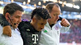 Le Français Kingsley Coman sort du terrain blessé et aidé par deux membres du staff du Bayern face à Augsbourg