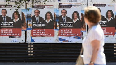 Une femme passe devant les affiches de campagne de Patrick Mennucci, candidat socialiste battus aux élections législatives, le 28 mai 2017 à Marseille.
