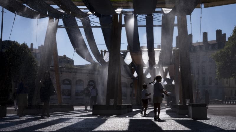 Les passants et les enfants profitent du brumisateur de l’installation Tissage urbain, sur la place Bellecour, pour se rafraichir face aux fortes chaleurs