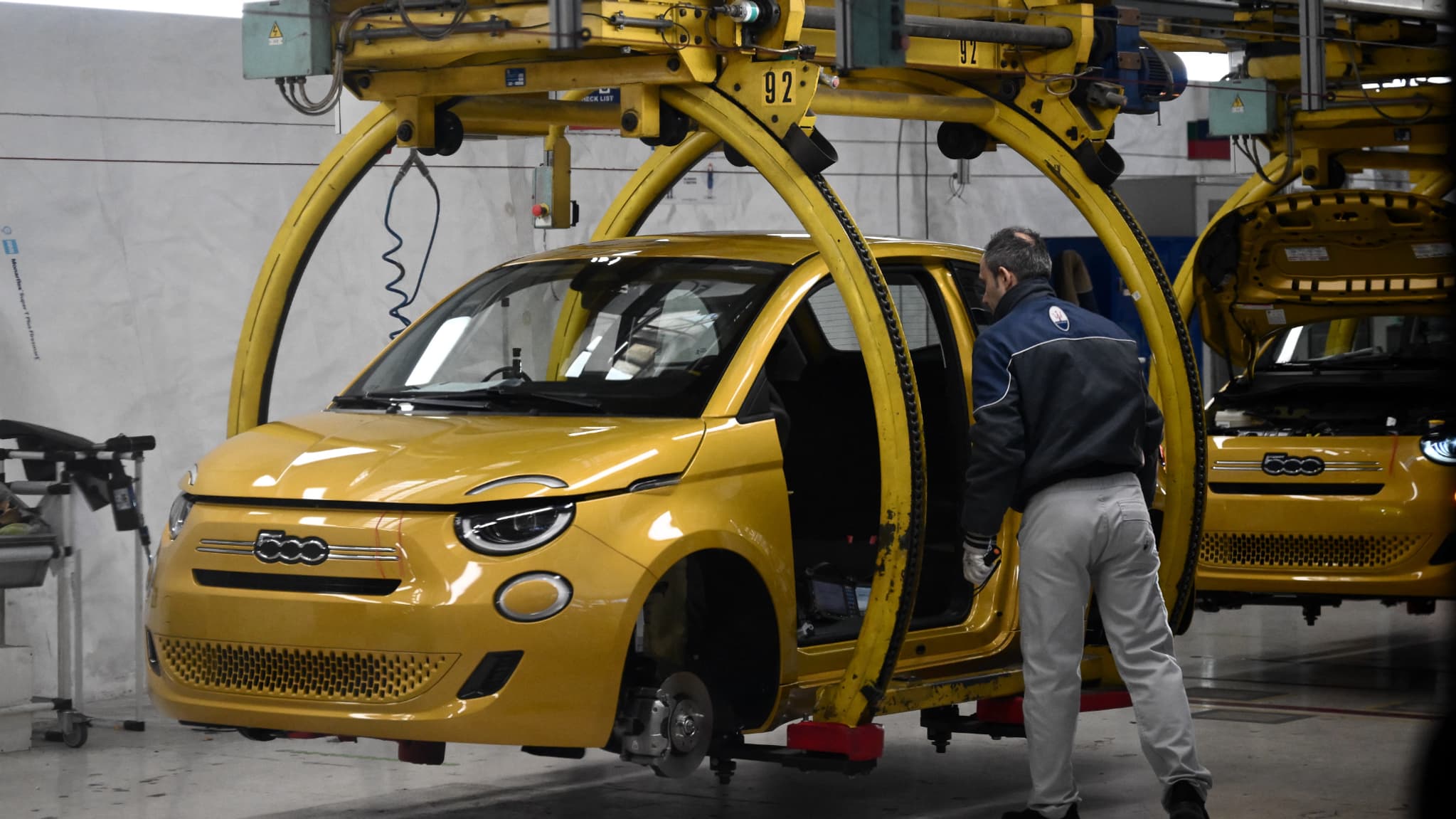 Un employé du géant automobile Stellantis travaille sur la chaîne de montage de la Fiat 500 Hybrid dans l'usine du constructeur automobile Mirafiori à Turin, lors de la présentation de la nouvelle 500 Hybrid à la presse, le 25 novembre 2025. Un employé du géant automobile Stellantis travaille sur la chaîne de montage de la Fiat 500 Hybrid dans l'usine du constructeur automobile Mirafiori à Turin, lors de la présentation de la nouvelle 500 Hybrid à la presse, le 25 novembre 2025.